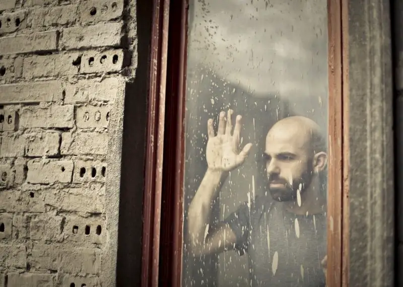 Man looking outside window during isolation or quarantine